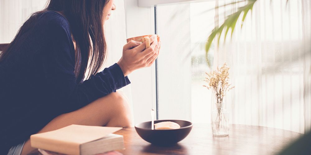 chica desayunando y mirando por la ventana